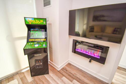 a video game machine next to a wall with a tv at Golf Paradise Pool Fire Pit King Bed in Innisfil