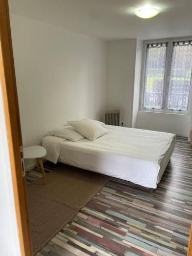 une chambre avec un lit blanc et une fenêtre dans l'établissement Appartement Bazilic, à Chessy