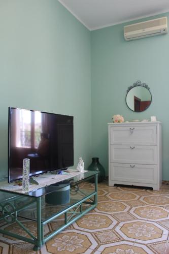 a living room with a large tv and a dresser at Garden House B&B in Striano