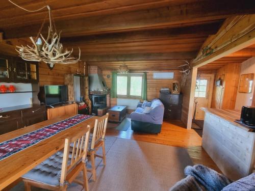 a living room with a couch and a table in a cabin at Blockhaus am See in Arvidsjaur