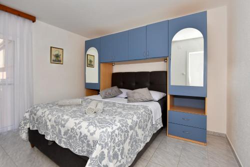 a bedroom with a large bed with a blue headboard at Kaurinovic in Zaton