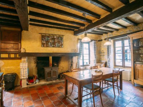 comedor con mesa y chimenea en Maison La Cloche, en Fourcès