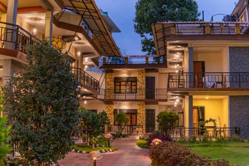 an apartment building with a tree in the courtyard at Moonlight Resort and Spa in Pokhara