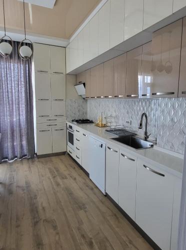 a kitchen with white cabinets and a sink at Magda's apartment in K'obulet'i