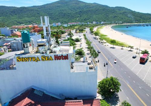 a building with a sign on it next to a beach at Sontra Sea Hotel in Da Nang