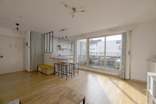 une cuisine et un salon avec une grande fenêtre dans l'établissement Le Mabilay, à Rennes