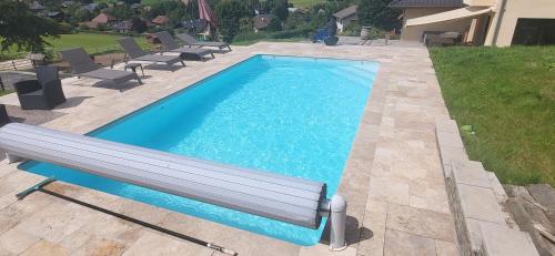 - une piscine avec un banc dans la cour dans l'établissement Villa avec piscine, à Cusy