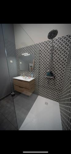 une salle de bain avec un lavabo et un miroir dans l'établissement Appartement de l ancienne poste, à Chalon-sur-Saône