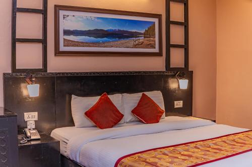a hotel room with a bed with red pillows at Moonlight Resort and Spa in Pokhara