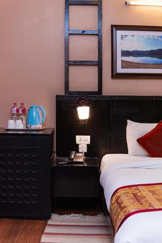 a bedroom with two beds and a phone on a table at Moonlight Resort and Spa in Pokhara