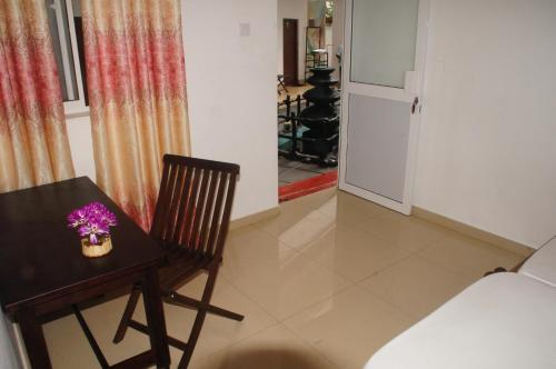 a room with a table and a chair with purple flowers on it at Ritas Hotel in Hikkaduwa