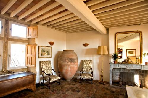 un salon avec un grand vase et deux chaises dans l'établissement La maison Renaissance, à Grambois