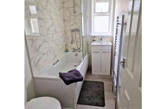 a bathroom with a tub and a toilet and a sink at Cosy 4 Bedroom House in Seven Sisters Neath Port Talbot in Seven Sisters