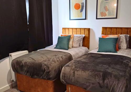 two beds sitting next to each other in a bedroom at Cosy 4 Bedroom House in Seven Sisters Neath Port Talbot in Seven Sisters