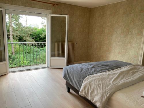 a bedroom with a bed and a sliding glass door at 5 Chambres dans une grande maison in Auneau