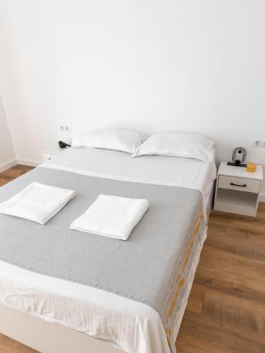 - un lit blanc avec des draps et des oreillers blancs dans l'établissement Appartement 3 chambres, à Fréjus