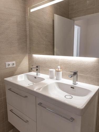 une salle de bain avec un lavabo blanc et un miroir dans l'établissement Appartement 3 chambres, à Fréjus