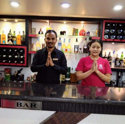 a man and a woman standing behind a bar at Hotel Royal Inn Nuwakot in Trisūli Bāzār
