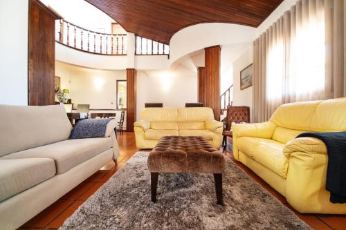 a living room with yellow furniture and a yellow couch at Villa Salgado in Gafanha da Nazaré