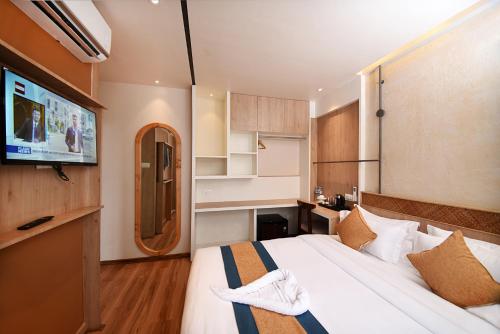 a bedroom with a bed and a flat screen tv at Hotel Vistara in Kathmandu