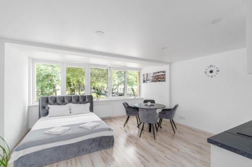 una camera da letto bianca con un letto e un tavolo di MALŪNO Cozy Corner SELF CHECK-IN a Klaipėda