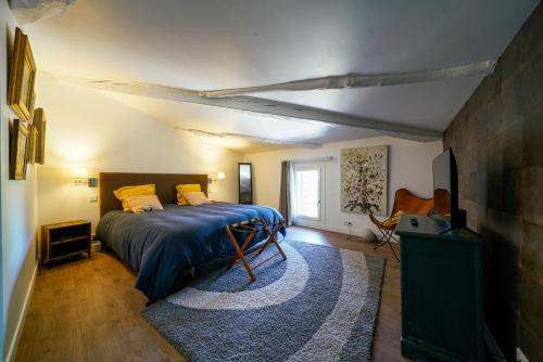 - une chambre avec un lit doté d'une couverture bleue et d'un tapis dans l'établissement Gîte en face du Château de NIZAS, 4 chambres d'hôtes et 1 appartement familial avec 2 chambres, à Nizas