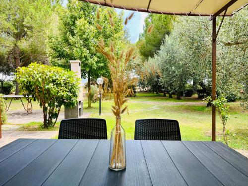 a wooden table with a vase with flowers in it at Agriturismo Salcino in Grosseto