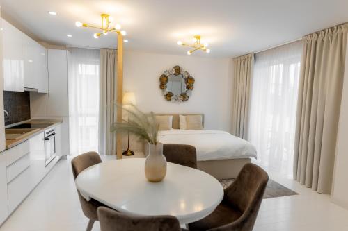 a white room with a bed and a table and chairs at Studio Vivo Residence in Baia Mare
