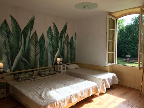 - 2 lits dans une chambre ornée d'une grande peinture murale dans l'établissement domaine des CHABRIERS, à Ourches