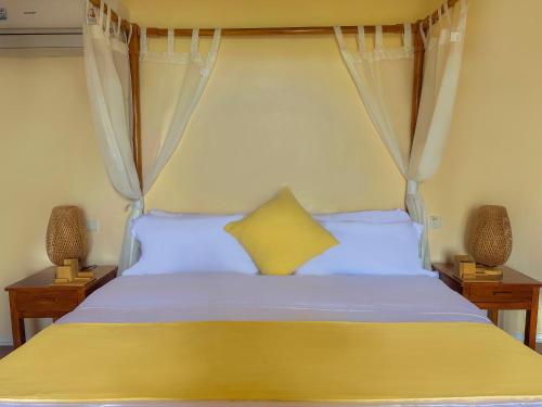 a bedroom with a large bed with a yellow pillow at InSense Mountainview Resort in Siquijor