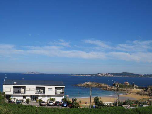 una casa en una colina junto a una playa en Hotel Foxos, en A Lanzada
