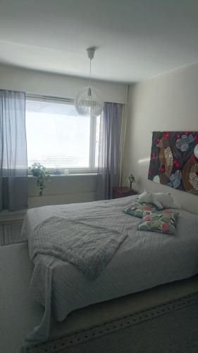 a bedroom with a large bed and a window at Apartment Rauha in Rovaniemi