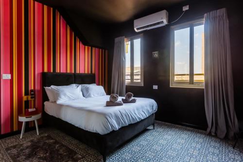 a bedroom with a bed with two teddy bears on it at Ninna Palatin in Haifa