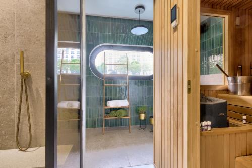 une salle de bain avec une douche avec une porte vitrée dans l'établissement Beautiful boathouse in Paris for JO, à Puteaux