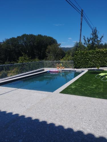 a swimming pool in a yard with a fence at Casa das Andorinhas in Póvoa de Lanhoso