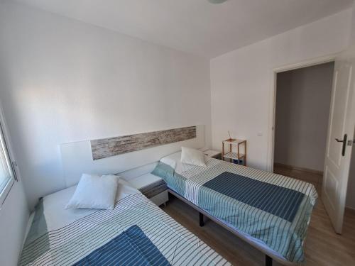two beds in a small room with a window at Apartment near sea Nortico 5 Torrevieja Spain in Torrevieja