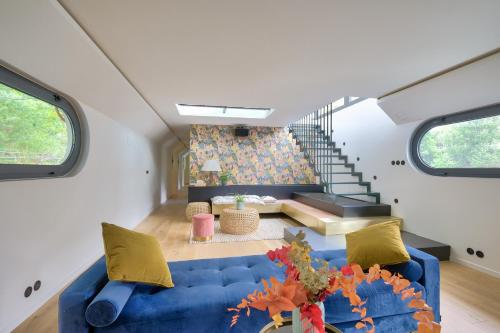 - un salon avec un canapé bleu et des escaliers dans l'établissement Beautiful boathouse in Paris for JO, à Puteaux