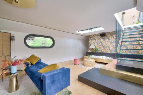 un salon avec un canapé bleu et une fenêtre dans l'établissement Beautiful boathouse in Paris for JO, à Puteaux