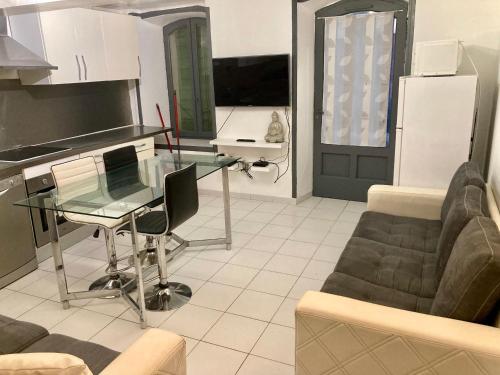 un salon avec une table en verre et un canapé dans l'établissement Appartement de village complet tout confort, à Noves