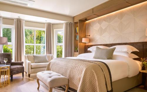 a bedroom with a large bed and a chair at Brook Lane Hotel in Kenmare