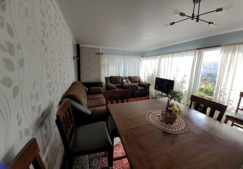 a living room with a table and a couch at Casa magallanica in Punta Arenas