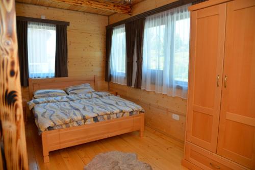 a bedroom with a bed in a room with windows at Zagrad Homes in Zabljak in Žabljak