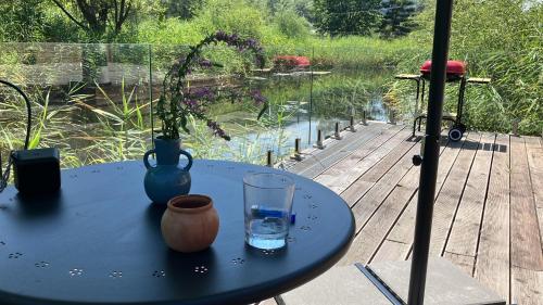 a blue table with a vase and a glass on a deck at Two Tiny Houses in Agarcia