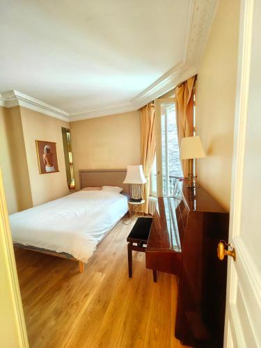 une chambre avec un lit, un bureau et une fenêtre dans l'établissement Beautiful Apartment Eiffel Tower, à Paris