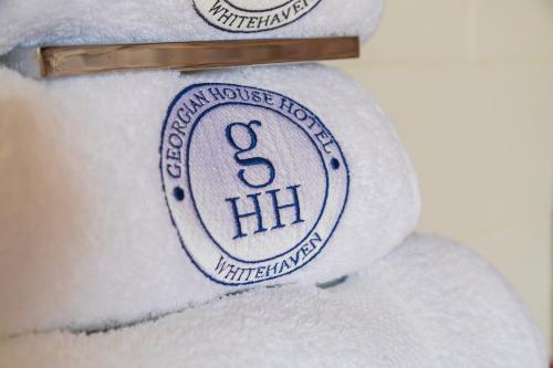 a pile of white towels with a sign on them at Georgian House Hotel in Whitehaven