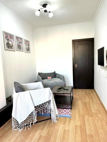 a living room with a bed and a wooden floor at Cozy 2 rooms apartment in the center, free WiFi in Dushanbe