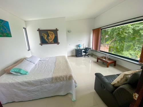 a bedroom with a bed and a couch and a large window at Lujosa finca en La Cumbre, Piscina, jacuzzi, WiFi, 5BR in La Cumbre