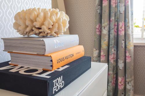a stack of books on a table with a plant on top at Georgian House Hotel in Whitehaven