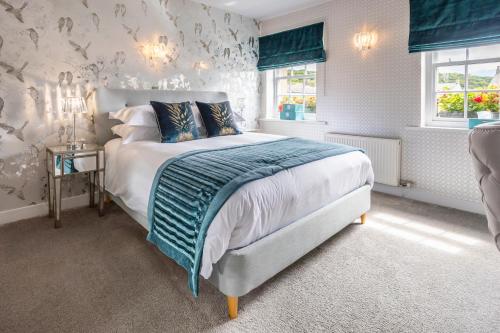 a bedroom with a bed with a blue and white comforter at Georgian House Hotel in Whitehaven