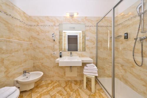 a bathroom with a sink and a shower at Hotel Geier in Nago-Torbole